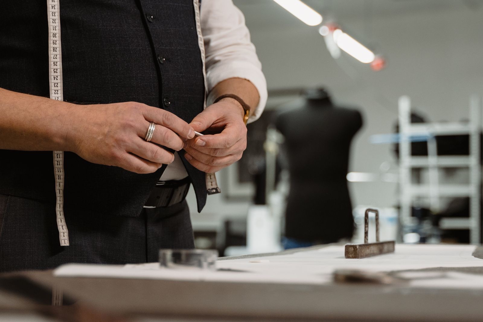 Mains d’un tailleur ajustant une pièce sur un mannequin à l’atelier