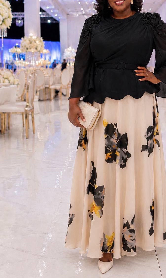 Blouse noire portée avec une jupe longue crème à fleurs